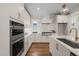 Well-lit white kitchen with marble backsplash, stainless steel appliances, and a large island for cooking at 109 W Markham Ave, Durham, NC 27701