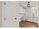 Laundry room with white shaker cabinets, stylish lighting, and hardwood floors at 109 W Markham Ave, Durham, NC 27701