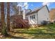 Backyard view of a multi-story home with deck, showing a grass lawn and wooded background at 12 Citation Dr, Durham, NC 27713