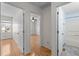Hallway featuring doorways to a bedroom and bathroom, hardwood floors and neutral paint at 12 Citation Dr, Durham, NC 27713