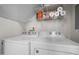 Bright laundry room with modern appliances and convenient storage shelving at 12 Citation Dr, Durham, NC 27713