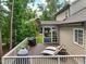 Relaxing back deck with outdoor seating, BBQ, and view of the screened-in porch and lush yard at 1328 Mill Glen Cir, Raleigh, NC 27614