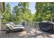 Deck with lounge chairs, grill, wood floor and fenced in yard with forest views at 1328 Mill Glen Cir, Raleigh, NC 27614