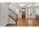 Inviting foyer featuring hardwood floors, a staircase with decorative iron railings, and natural light at 1328 Mill Glen Cir, Raleigh, NC 27614