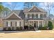 Charming home featuring a welcoming covered porch, manicured landscaping, and elegant architectural details at 1328 Mill Glen Cir, Raleigh, NC 27614