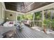 Enclosed porch with green walls, wicker seating, black ceiling and a ceiling fan with forest views at 1328 Mill Glen Cir, Raleigh, NC 27614