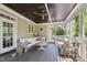 Enclosed porch with green walls, wicker seating, black ceiling and a ceiling fan at 1328 Mill Glen Cir, Raleigh, NC 27614