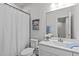 Bright bathroom featuring a single sink vanity, toilet, framed mirror, and a shower with a white curtain at 1329 Channing Park Cir, Cary, NC 27519