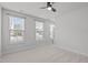 A well-lit bedroom has three windows, a ceiling fan, and a door to exit at 1329 Channing Park Cir, Cary, NC 27519
