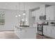 Bright kitchen features white cabinets, stainless steel appliances, and a center island with pendant lighting at 1329 Channing Park Cir, Cary, NC 27519