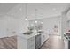 Well-lit kitchen boasts stainless steel appliances, a center island with seating, and access to the outdoor deck at 1329 Channing Park Cir, Cary, NC 27519