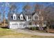 Side view of a white, two-story house with a two-car garage and well-maintained lawn and driveway at 15 Rocky Point Ct, Fuquay Varina, NC 27526