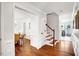 Inviting hallway with wood floors leading to a dining room and staircase with classic white trim at 15 Rocky Point Ct, Fuquay Varina, NC 27526