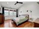 Bright bedroom features wood floors, modern light fixtures, ceiling fan, and three large windows at 15 Rocky Point Ct, Fuquay Varina, NC 27526