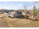 Expansive backyard showcasing the home's tan siding, well-maintained lawn, and tree coverage at 16 Eagle Swoop St, Zebulon, NC 27597