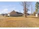 View of the home's rear exterior, large backyard and outbuilding shed at 16 Eagle Swoop St, Zebulon, NC 27597