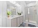 Bright bathroom featuring double sinks, large mirror, and glass enclosed shower at 16 Eagle Swoop St, Zebulon, NC 27597
