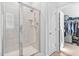 Tiled walk-in shower with a door and shelving, plus a peek into a walk-in closet at 16 Eagle Swoop St, Zebulon, NC 27597