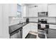 Bright kitchen features stainless steel appliances, white cabinets, and sleek black countertops at 16 Eagle Swoop St, Zebulon, NC 27597
