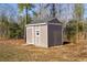 A beige shed with a single window and door sits in the backyard at 16 Eagle Swoop St, Zebulon, NC 27597
