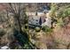 An aerial view of a white two-story house with dark roof and large wooded backyard and small garden shed at 1708 Lakepark Dr, Raleigh, NC 27612