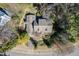 A beautiful aerial view of a brown home with gray roof, many trees, and partial circular driveway at 1708 Lakepark Dr, Raleigh, NC 27612