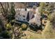 An aerial view of a white two-story house with dark roof and large wooded backyard with fire pit at 1708 Lakepark Dr, Raleigh, NC 27612