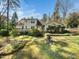 A backyard with a deck, landscaping, and a fountain at 1708 Lakepark Dr, Raleigh, NC 27612