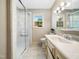 A stylish bathroom featuring a glass-enclosed shower and bright window for natural light at 1708 Lakepark Dr, Raleigh, NC 27612