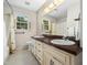 Dual vanity bathroom featuring tile flooring, a bright window, and neutral walls at 1708 Lakepark Dr, Raleigh, NC 27612