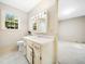 Bright bathroom featuring a classic vanity, neutral walls, and a large window for natural light at 1708 Lakepark Dr, Raleigh, NC 27612
