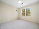 Neutral bedroom featuring carpet flooring, a large window, and light walls at 1708 Lakepark Dr, Raleigh, NC 27612