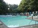 A community pool surrounded by trees and lounge chairs at 1708 Lakepark Dr, Raleigh, NC 27612