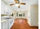 Well-lit kitchen with white cabinets, appliances, wood-look floors and a cozy dining area at 1708 Lakepark Dr, Raleigh, NC 27612
