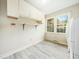 Functional laundry room with storage cabinets and a window, providing a bright and practical space at 1708 Lakepark Dr, Raleigh, NC 27612
