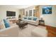 Bright living room with hardwood floors, cream furnishings, and large windows for natural light at 1708 Lakepark Dr, Raleigh, NC 27612