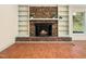 Cozy living room featuring a brick fireplace with built-in shelving, and a view to the backyard at 1708 Lakepark Dr, Raleigh, NC 27612