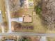 Charming aerial view of a home with a gravel driveway and carport, plus a shed and above ground pool out back at 1723 Bahama Rd, Bahama, NC 27503