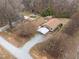 This aerial view shows the home's gravel driveway, carport, backyard, and neighborhood trees surrounding the property at 1723 Bahama Rd, Bahama, NC 27503