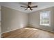 This bedroom has a large window, ceiling fan and wood-look flooring at 1723 Bahama Rd, Bahama, NC 27503