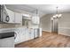 Bright kitchen featuring white cabinets, stainless steel appliances, and wood floors at 1723 Bahama Rd, Bahama, NC 27503