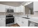 Modern kitchen featuring stainless steel appliances and white cabinets with solid surface countertops at 1723 Bahama Rd, Bahama, NC 27503