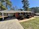 Charming red brick home with well-manicured lawn, complemented by a convenient carport and black shutters at 1723 Lynne Ave, Henderson, NC 27536