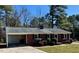 Classic red brick ranch-style home with mature trees, a carport, and neat landscaping enhances curb appeal at 1723 Lynne Ave, Henderson, NC 27536