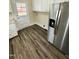 Kitchen with stainless refrigerator, white cabinets and modern flooring at 1723 Lynne Ave, Henderson, NC 27536