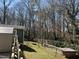 Large backyard with wooden fence, a playground and plenty of trees, perfect for outdoor activities at 1816 Phillips Dr, Sanford, NC 27330
