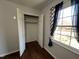 Bedroom closet with bi-fold doors, upper shelving, and a nearby window at 1816 Phillips Dr, Sanford, NC 27330