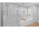 Elegant bathroom showcasing a walk-in shower with glass door, a soaking tub, and a window for natural light at 1900 Sunset Ave, Durham, NC 27705