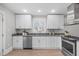 Bright kitchen featuring stainless steel appliances, white cabinets, and stone countertops at 1900 Sunset Ave, Durham, NC 27705