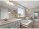 Bright bathroom featuring double vanity, soaking tub, tiled shower, and tile floors at 2005 Ernesto Ln, Raleigh, NC 27603
